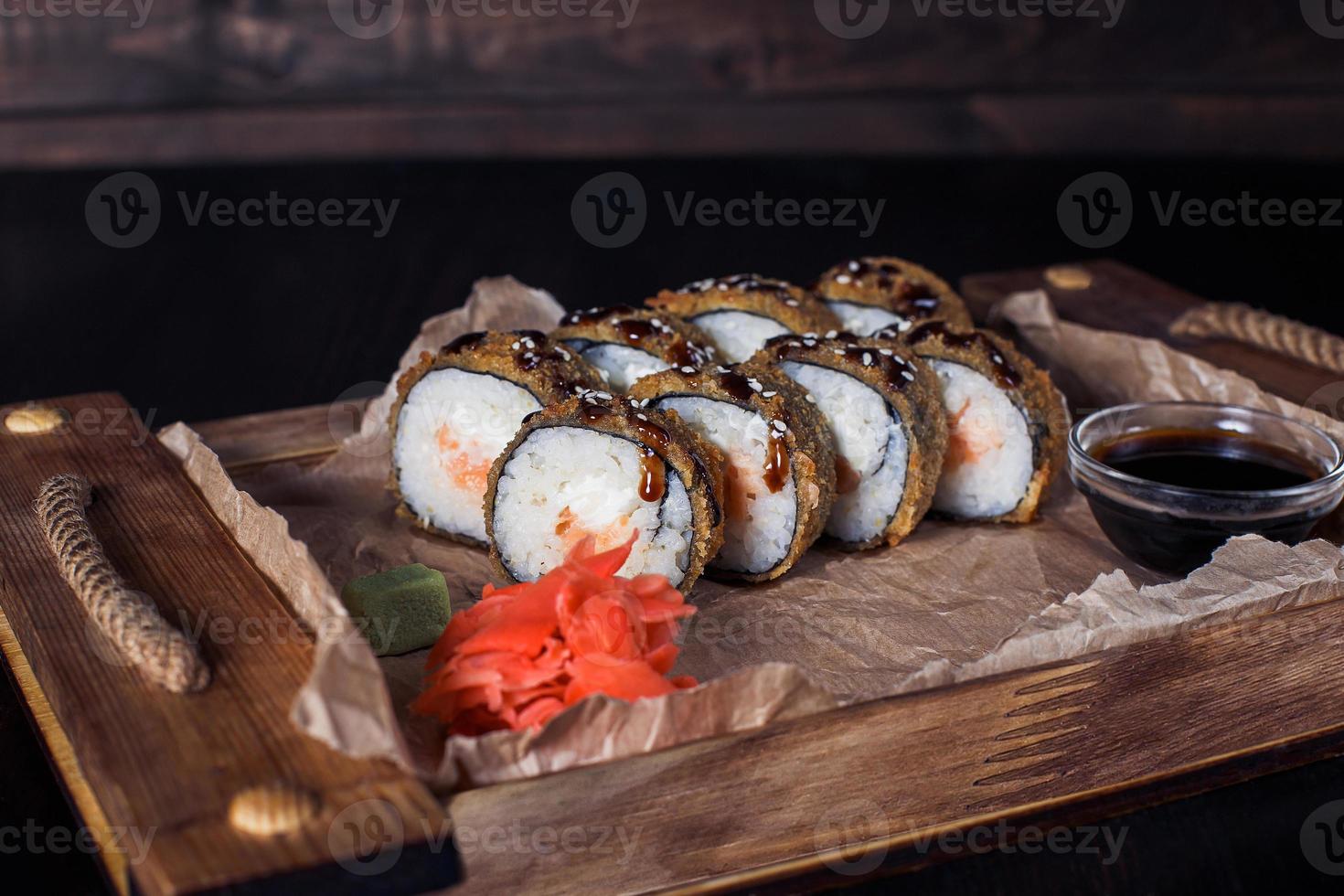 seafood rolls on a wooden tray, beautiful serving, dark background photo