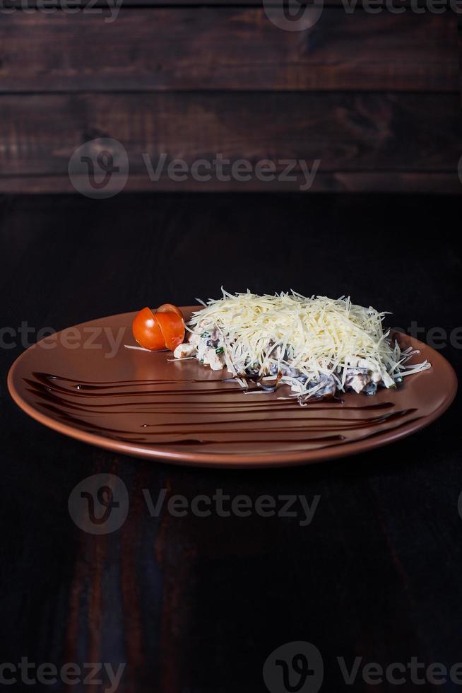 Ensalada de rosbif caliente en un plato, hermosa porción, fondo oscuro foto