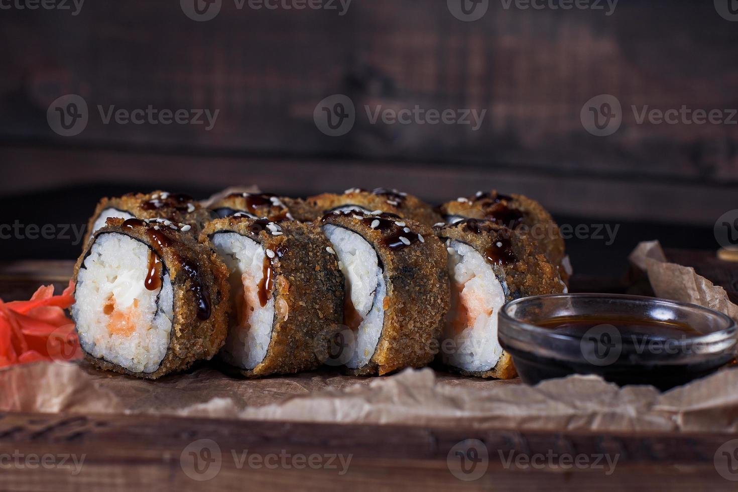 Rollos de mariscos en una bandeja de madera, hermosa porción, fondo oscuro foto