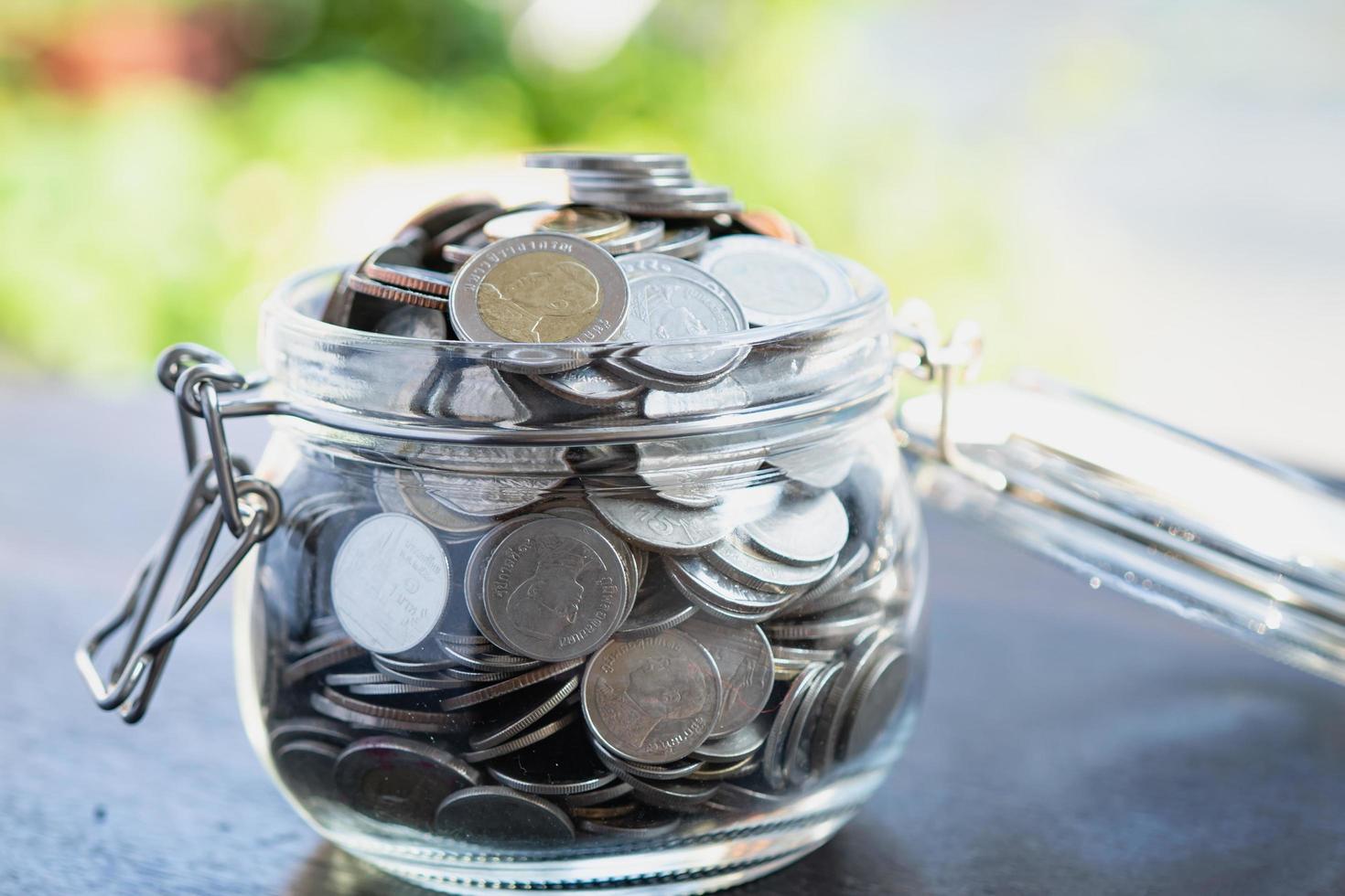 Ahorre dinero monedas en frasco de hierba foto