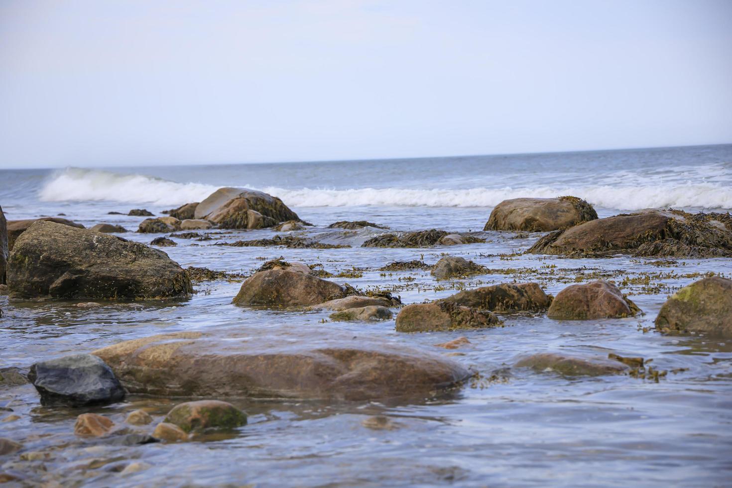 olas que bañan las rocas en el océano en el verano foto