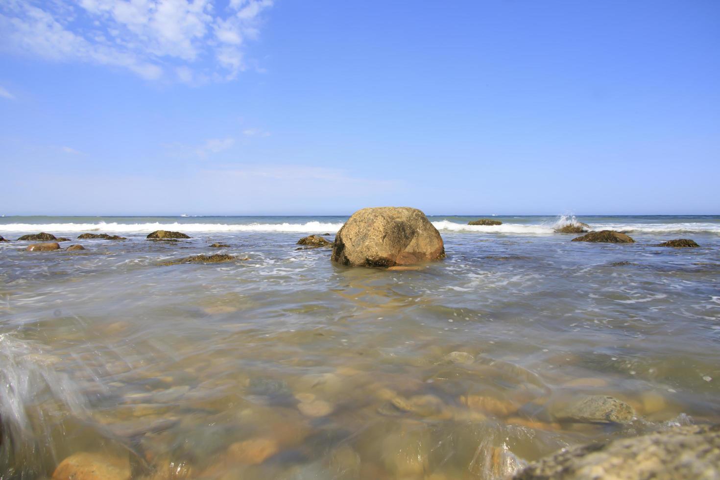 Waves washing over the rocks at the ocean in the summer photo