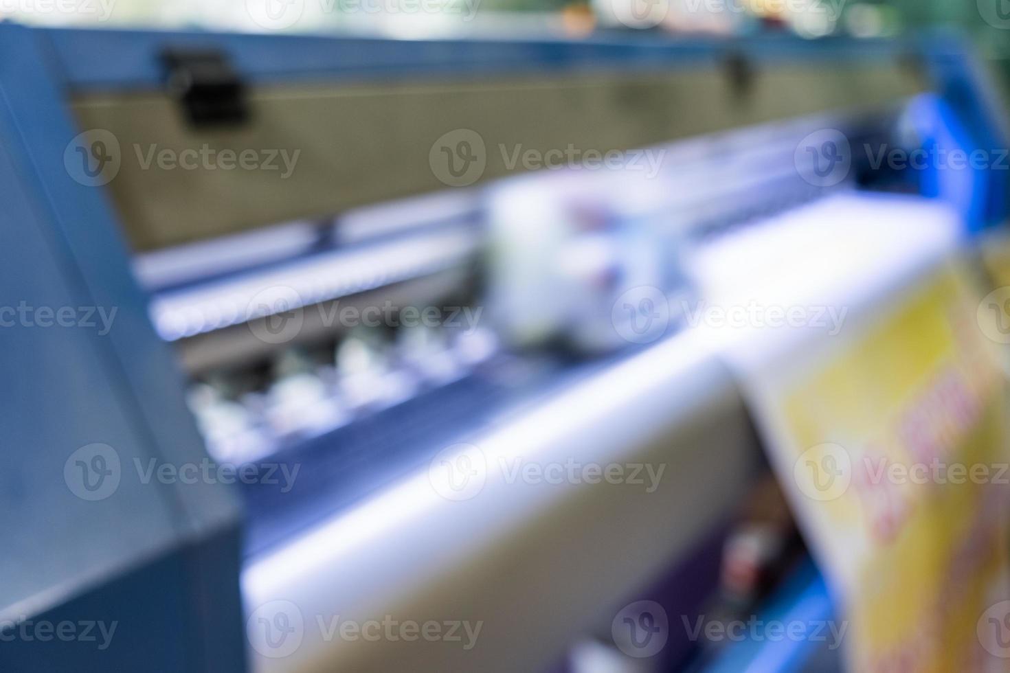 Escena borrosa color del cabezal de impresión de inyección de tinta trabajando en banner de vinilo foto