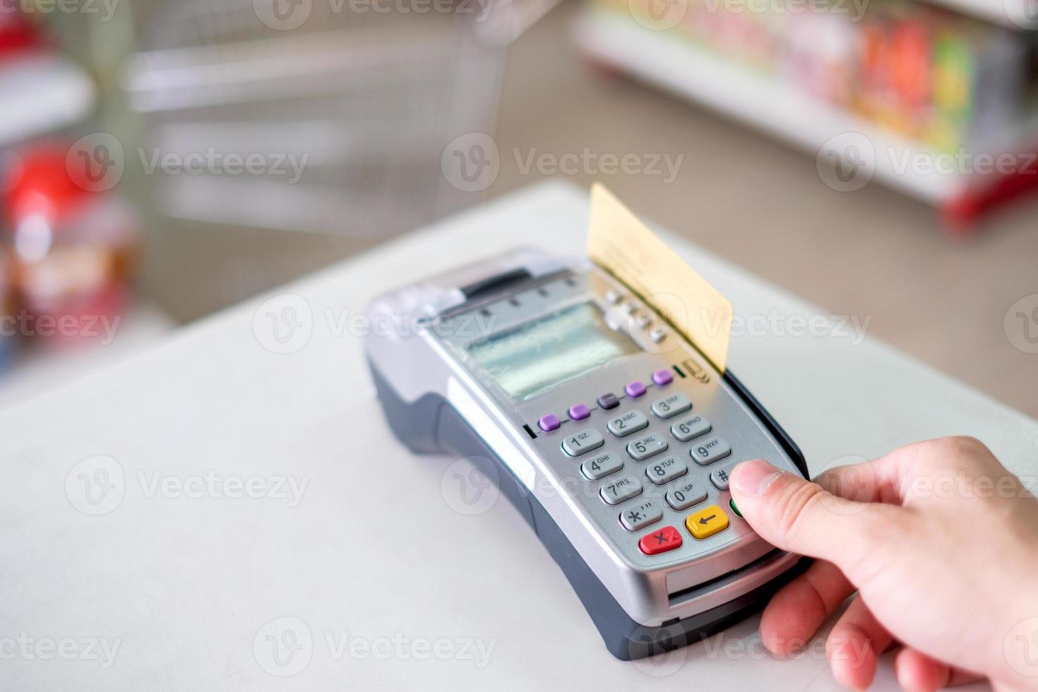 Hand press with swiping credit card on payment terminal in store photo