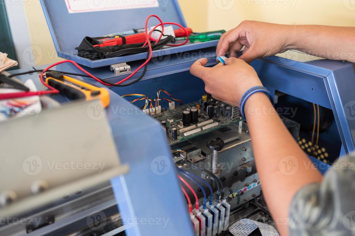 Technician repairing mainboard of colors dispensers of inkjet printer photo