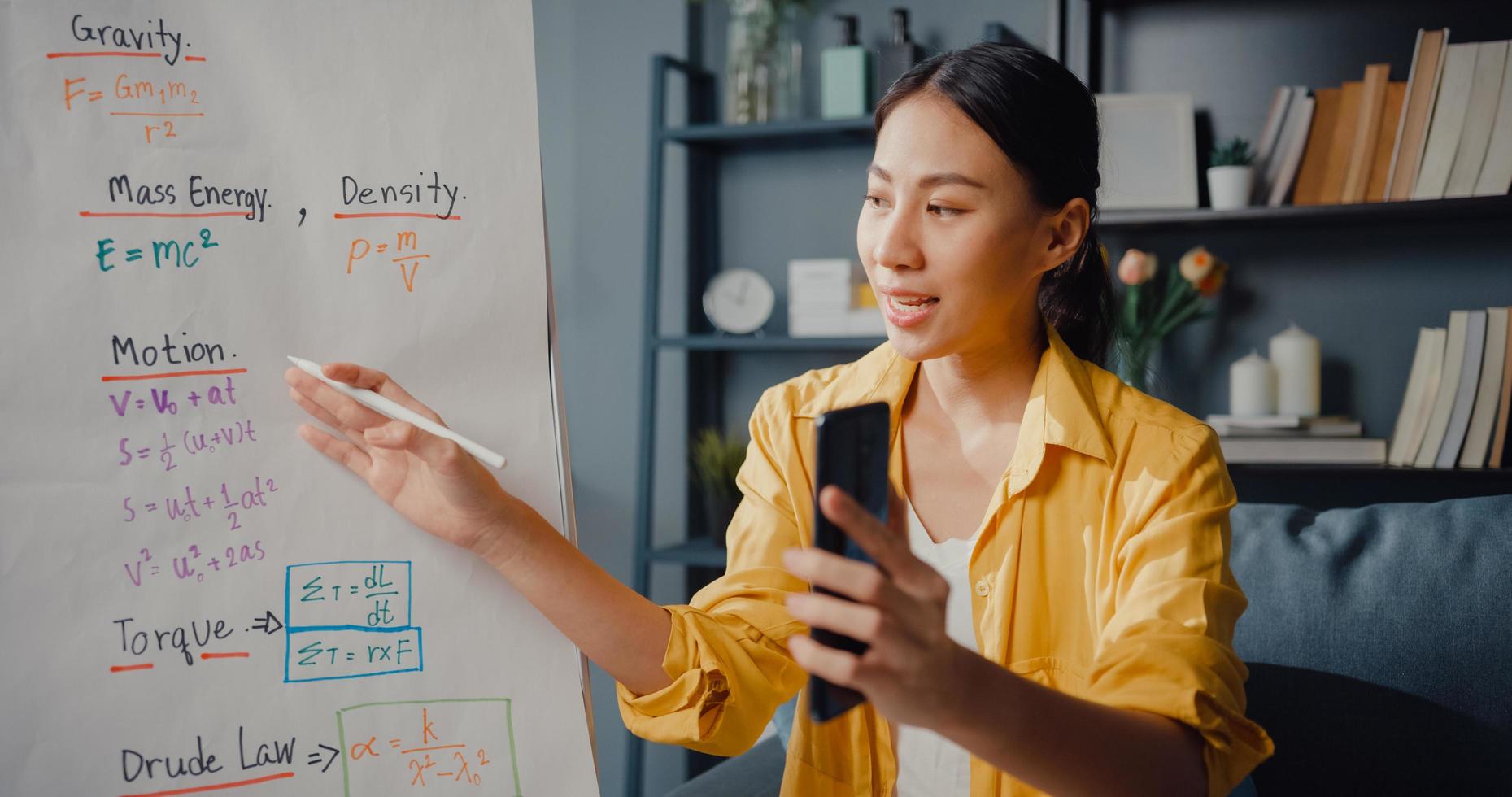 Young Asia lady teacher video conference calling on smartphone talk by webcam learn teach in online chat at home photo