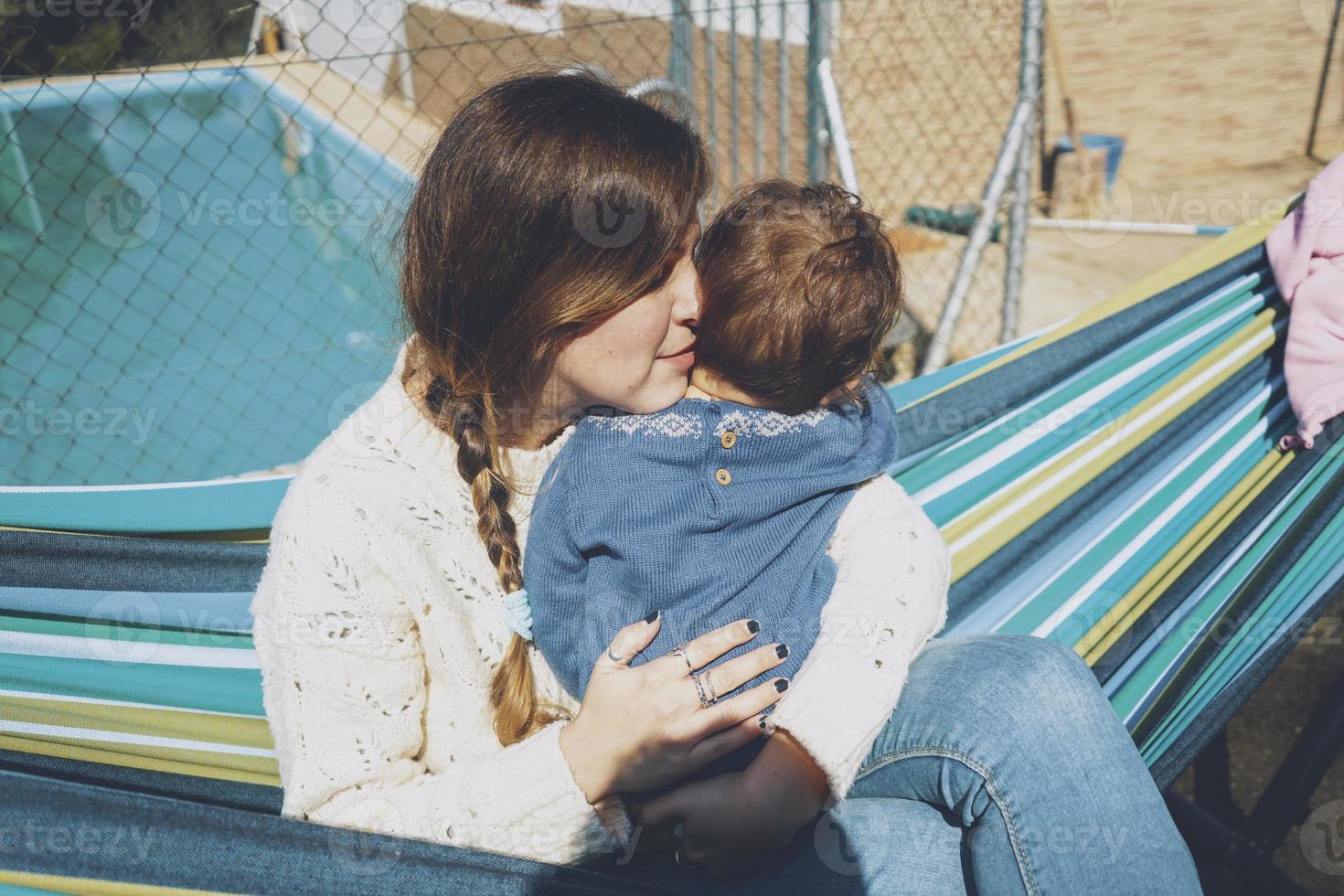 imagen sobre la maternidad real de una madre joven abrazando a su bebé foto