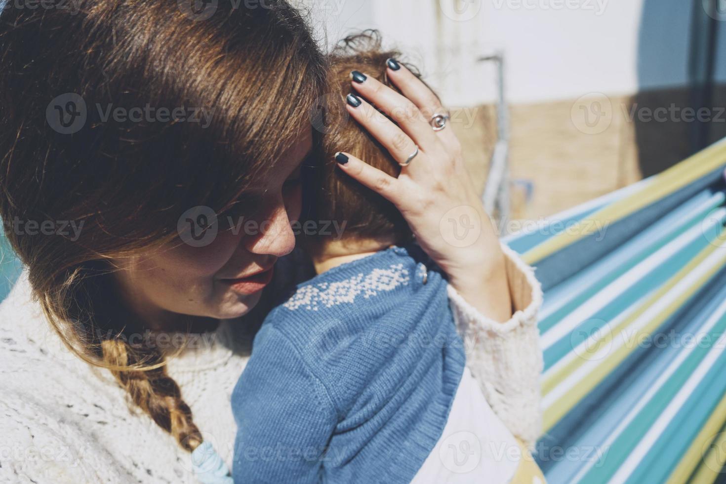 Image about real motherhood of a young mom hugging her baby photo