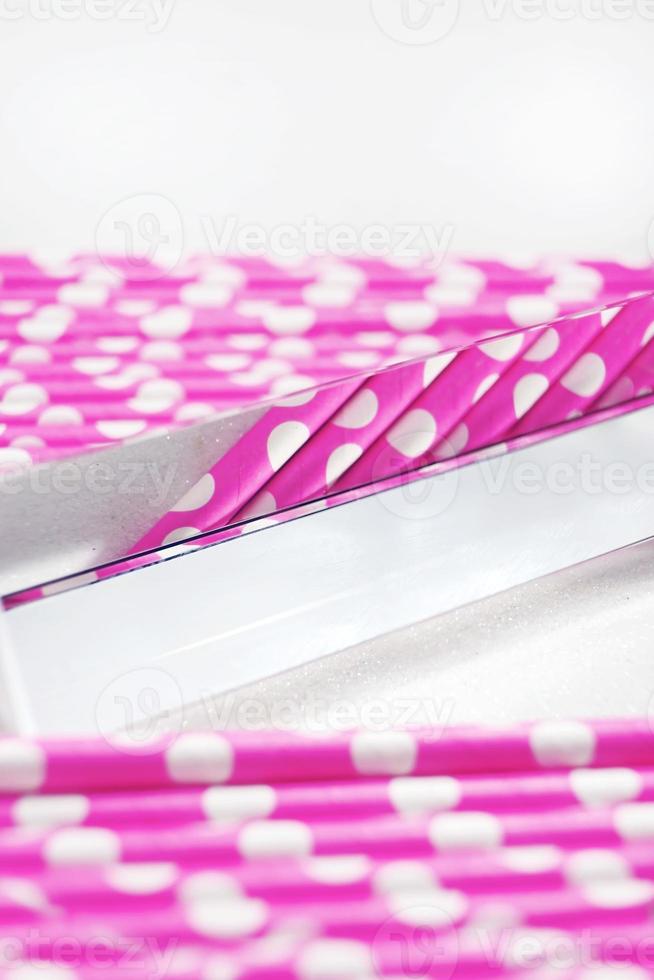 An amazing and beautiful macro with depth of field and space about pink straws with polka dots and a prism photo