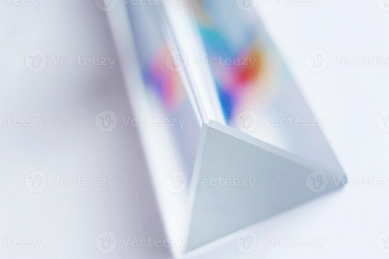 An amazing and beautiful macro with space and clearness about a crystal prism where it can be seen a rainbow on white background photo