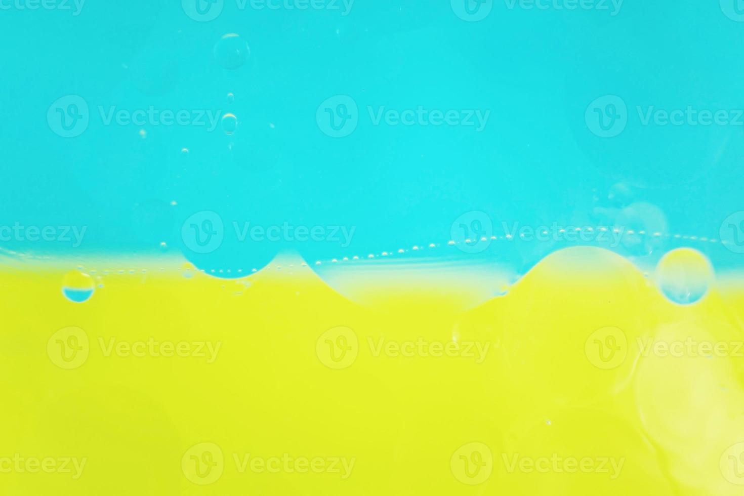 A beautiful and colorful macro of oil bubbles on water with two color as high contrast background, blue and yellow photo