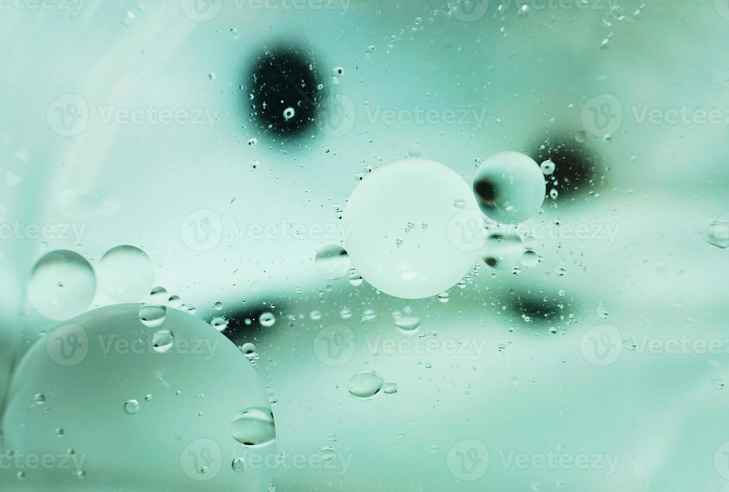 A beautiful and vibrant macro of oil bubbles on water with a black and white contrast texture as background pattern with vintage filter photo