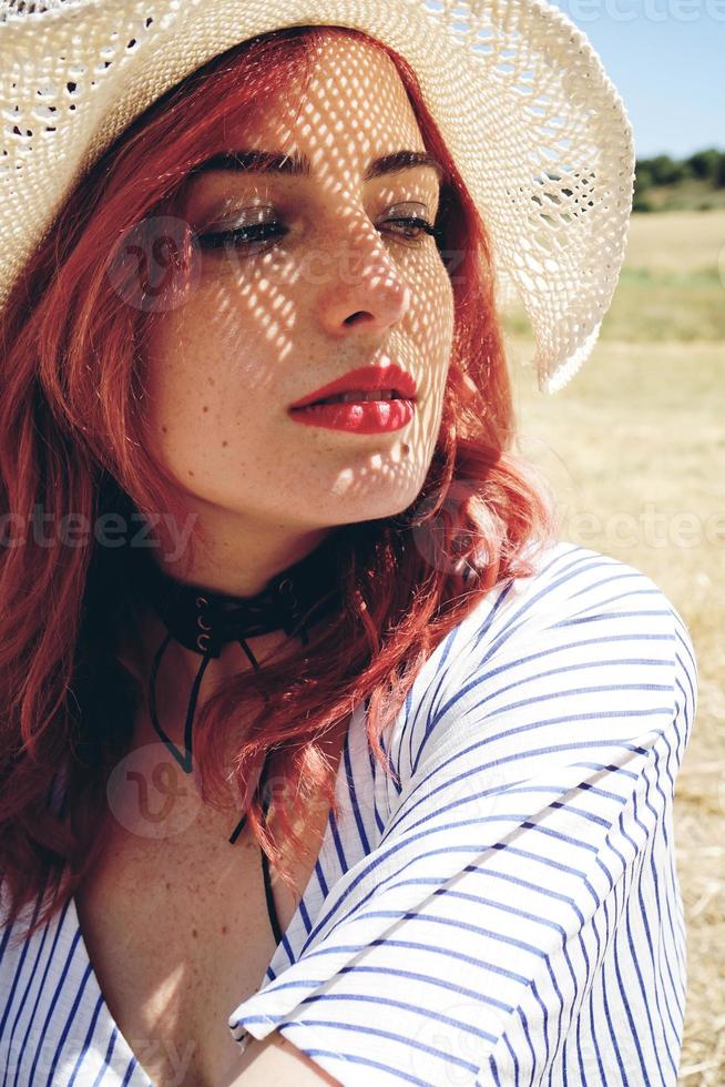 Young redhead woman covering from sun photo