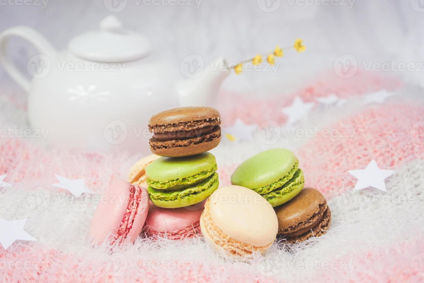 deliciosos macarons con un té en una tetera foto