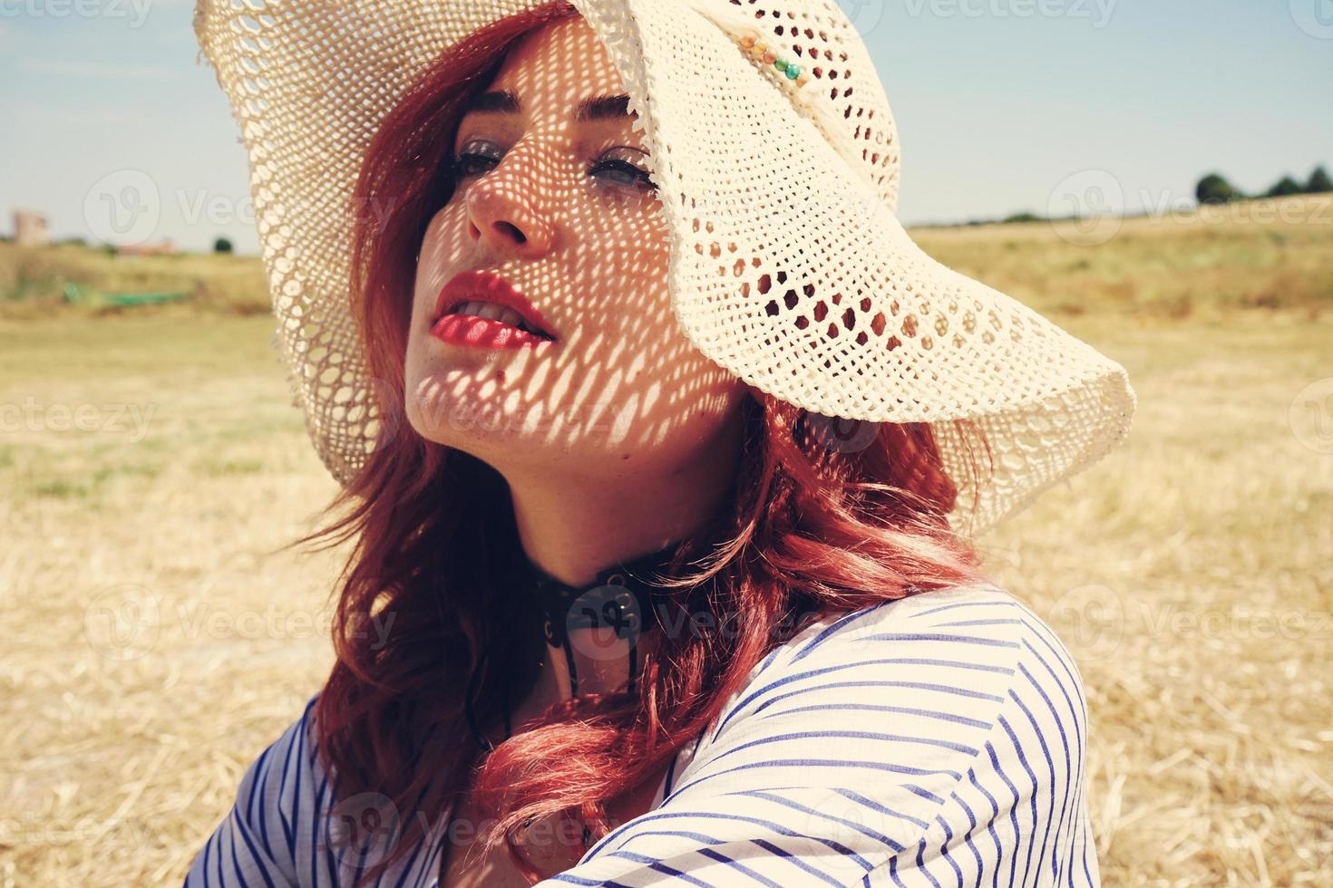 Young redhead woman covering from sun photo