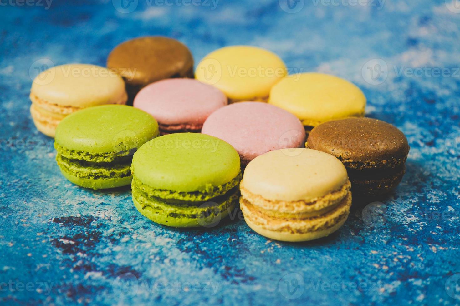 Variedad de macarons de colores sobre un fondo azul. foto