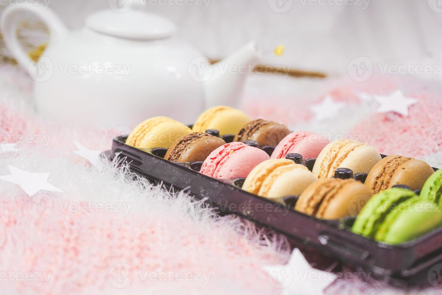 deliciosos macarons con un té en una tetera foto