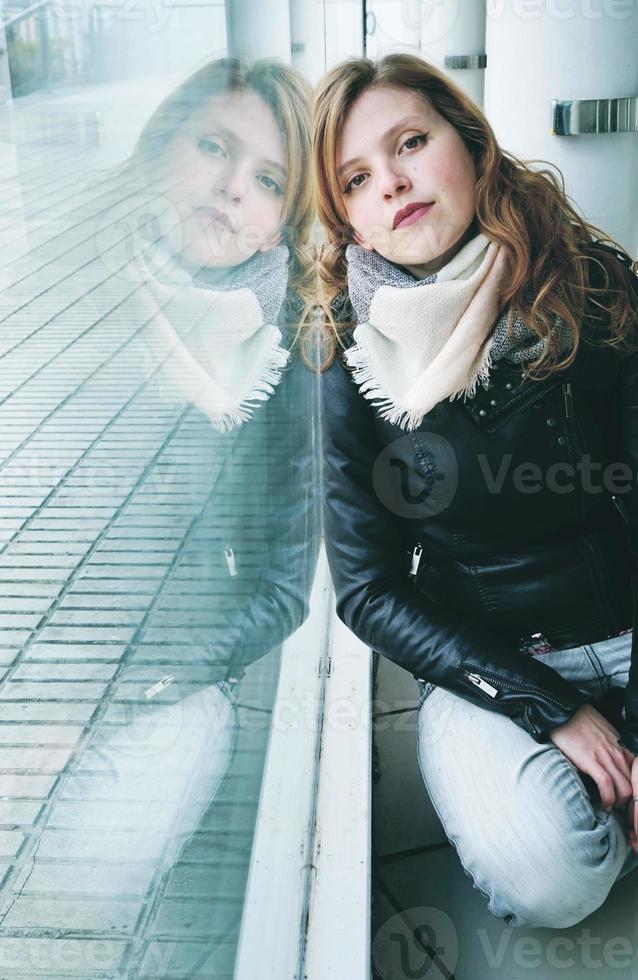 Mujer hermosa joven reflejada en una ventana enorme foto