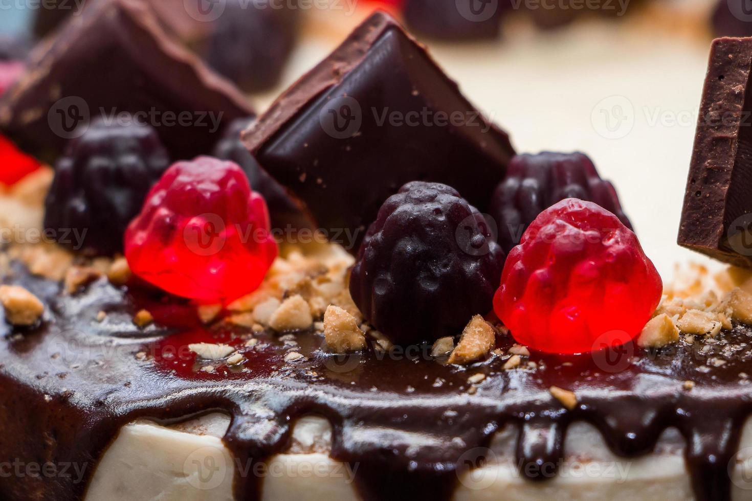 Beautiful festive cake with chocolate icing and marmalade on a background of flowers photo