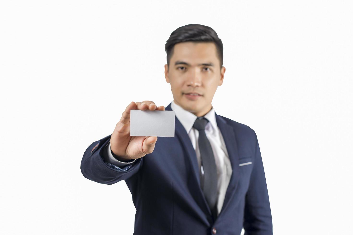 Apuesto empresario sosteniendo una tarjeta de presentación en blanco aislar sobre fondo blanco. foto