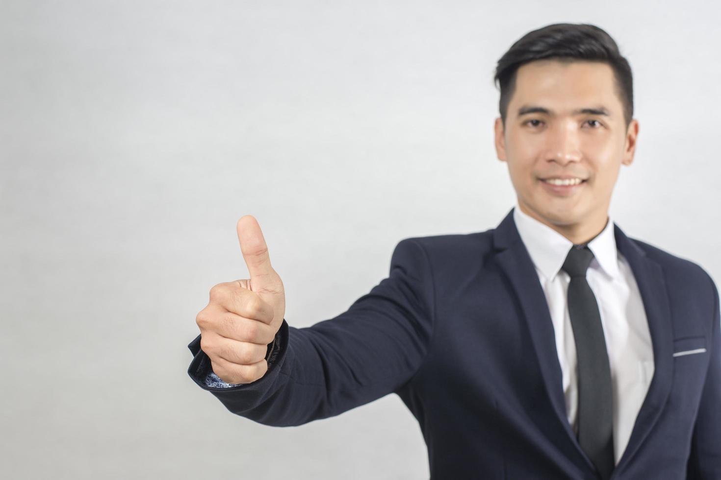 Handsome businessman Thumb up on gray photo