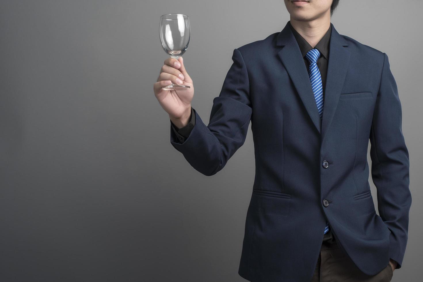 Close up of businessman in blue suit celebrating victory on gray background photo