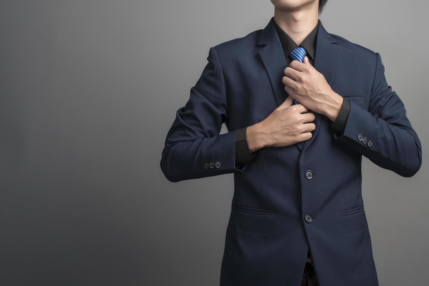 Close up of businessman in blue suit Wearing a necktie on gray background photo