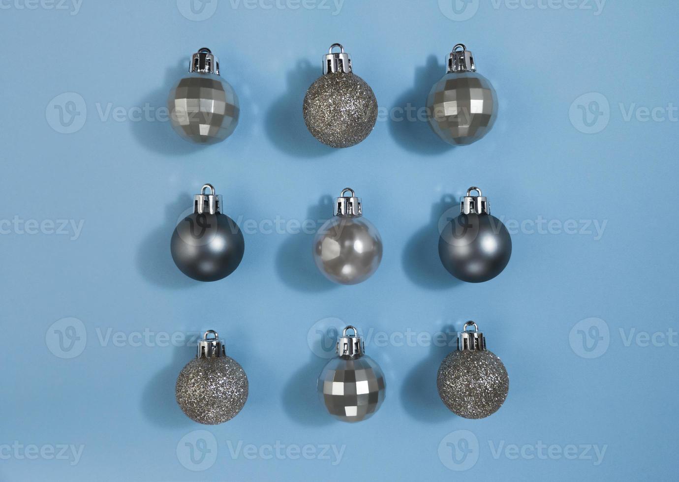 bolas de navidad de color metalizado sobre un papel azul pastel. plano de simetría festiva. foto