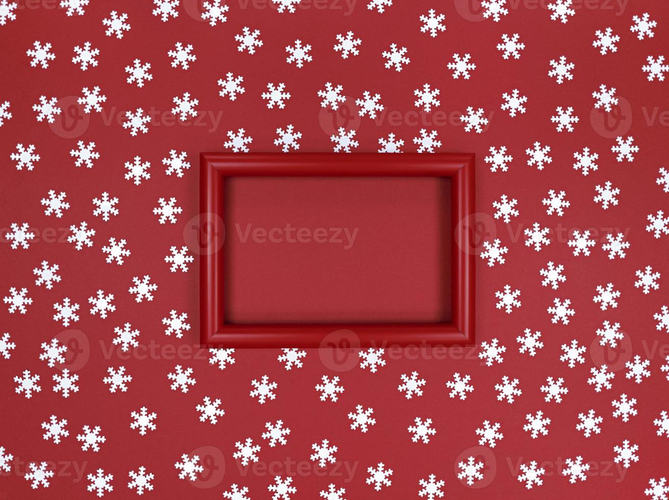 confeti de marco y copos de nieve sobre un fondo rojo. foto
