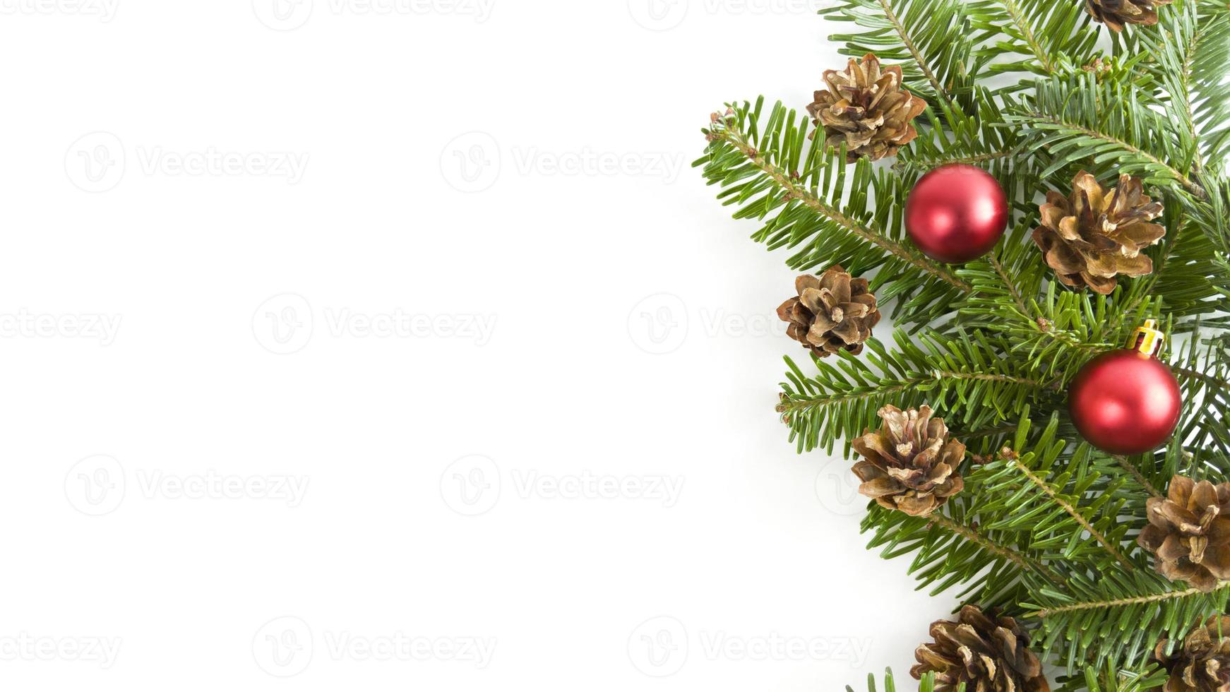 Holiday postcard with fir tree branches, cones and red baubles on a white background. Christmas banner with copy space. photo