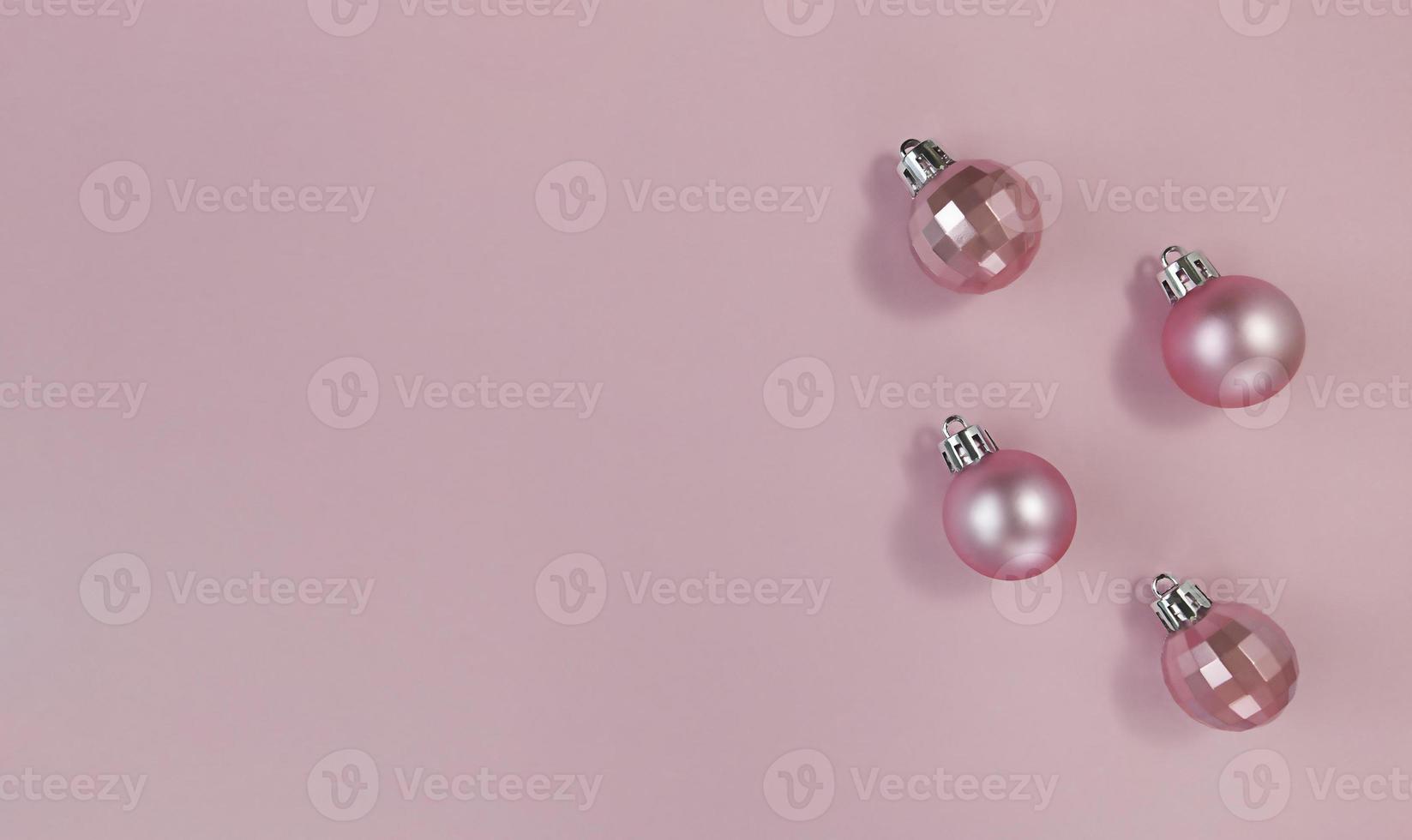 Pink Christmas balls on a pastel paper. Simple flat lay with copy space. photo