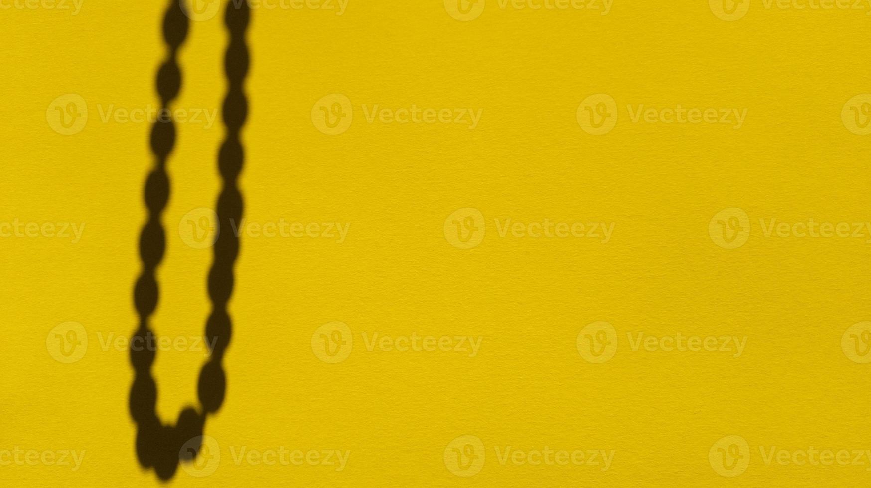 sombras de cuentas de japa sobre papel amarillo pastel. fondo abstracto. foto de stock.