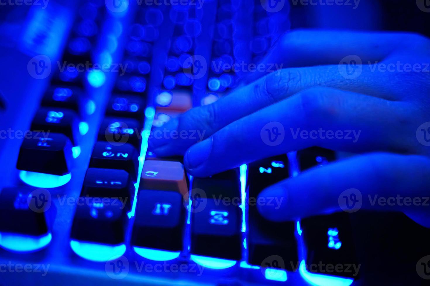 jugador usa teclado para juegos en neón azul foto