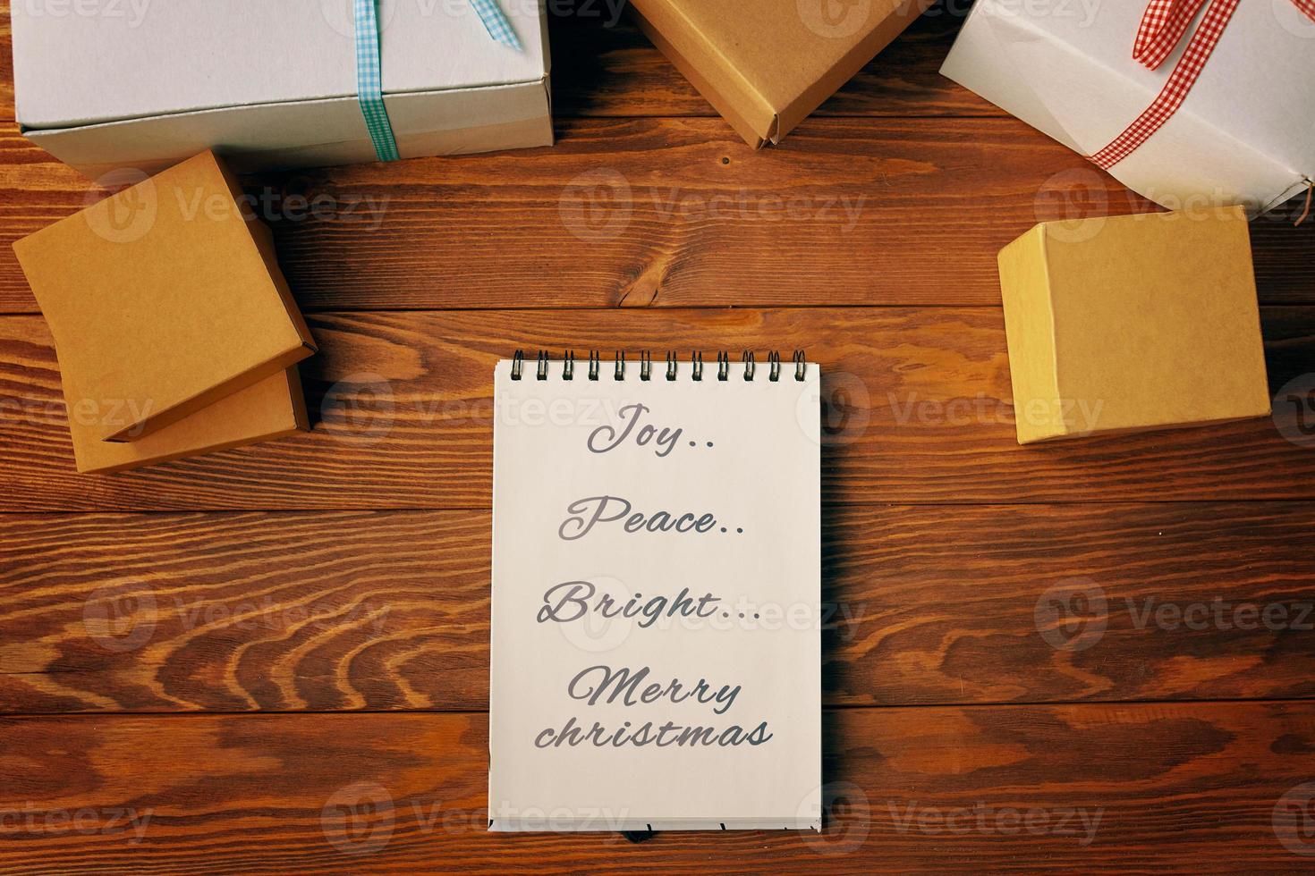 Top view of spiral notebook and gift boxes on wood table background. photo
