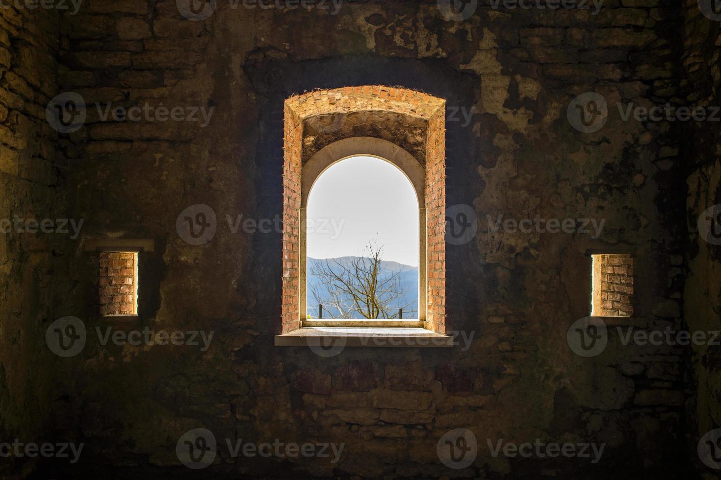 View of trees and mountains through an old window photo