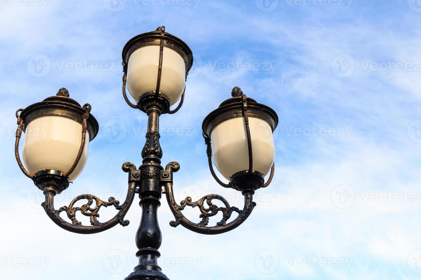 la farola y el cielo azul nublado con un área en blanco en el lado derecho foto