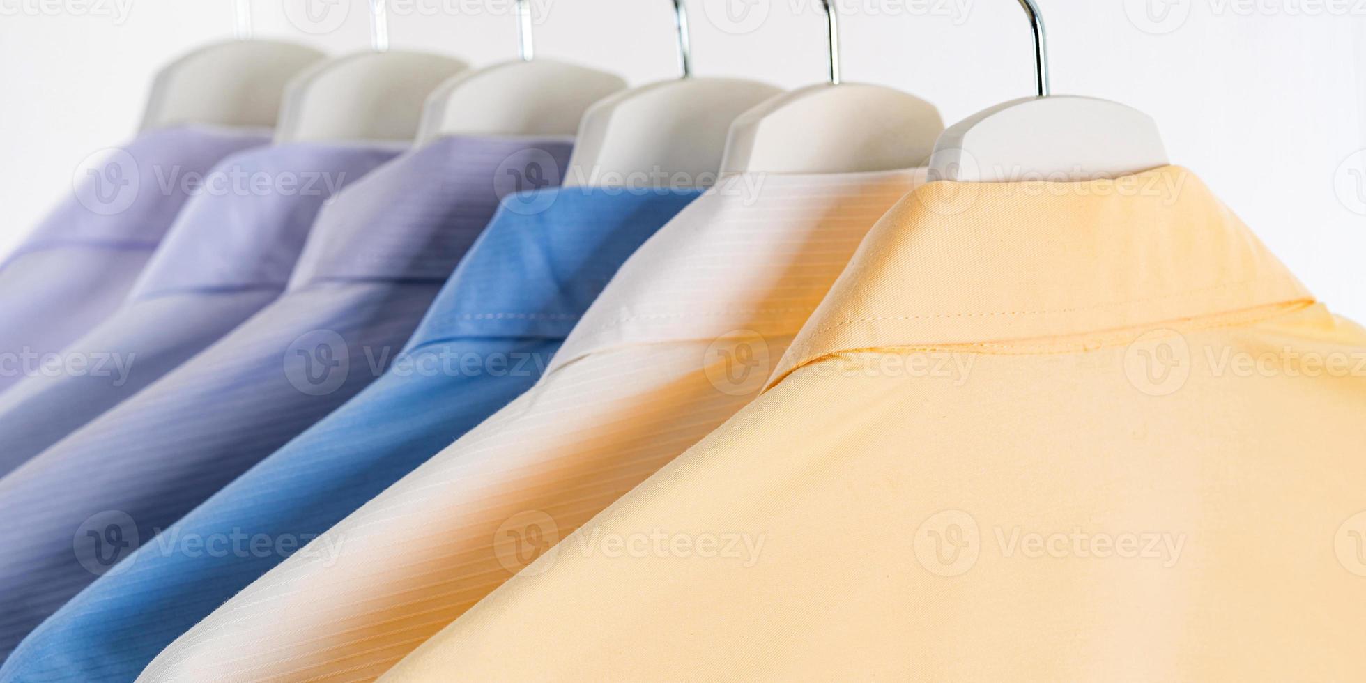 Men's dress shirts, Clothes on hangers on white background photo