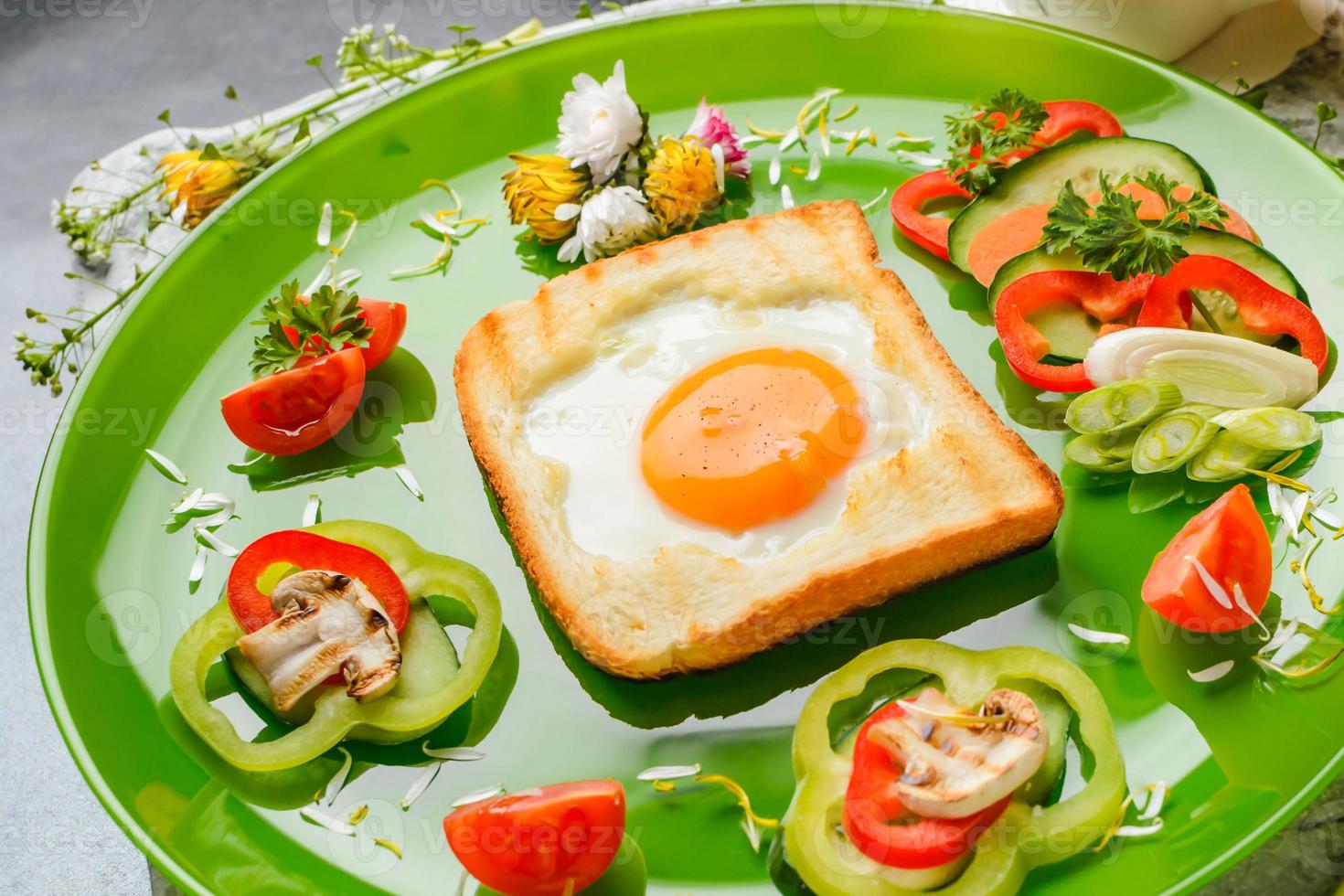 huevo en pan tostado horneado en forma de flor con verduras frescas foto