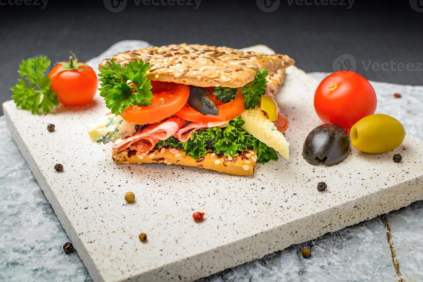 Cold appetizer. Prosciutto ham, blue cheese with tomatoes and olives photo