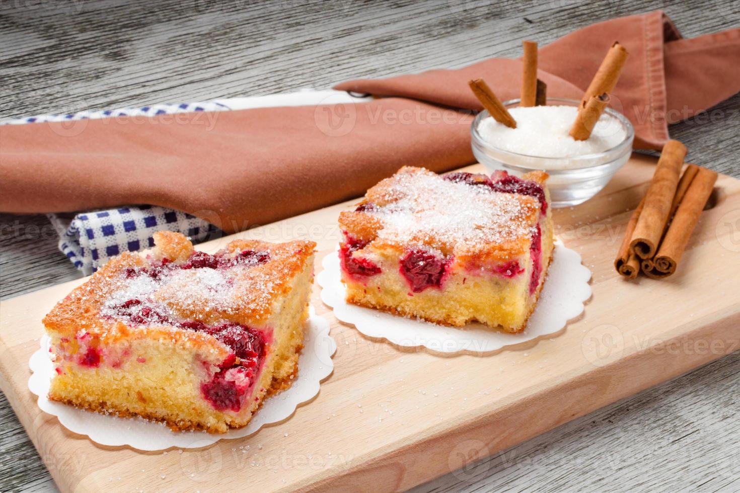 Sour cherry cake. Slices of sour cherry cake with sugar and cinnamon sticks. photo