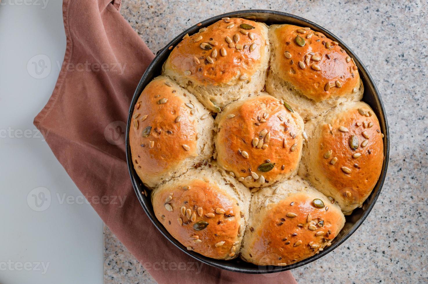 Loaf of bread on a kitchen worktable. Semisweet homemade bread with raisins, honey and various seeds. photo