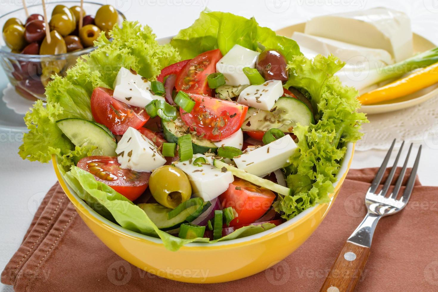 Greek salad with feta and tasty selection of vegetables. photo