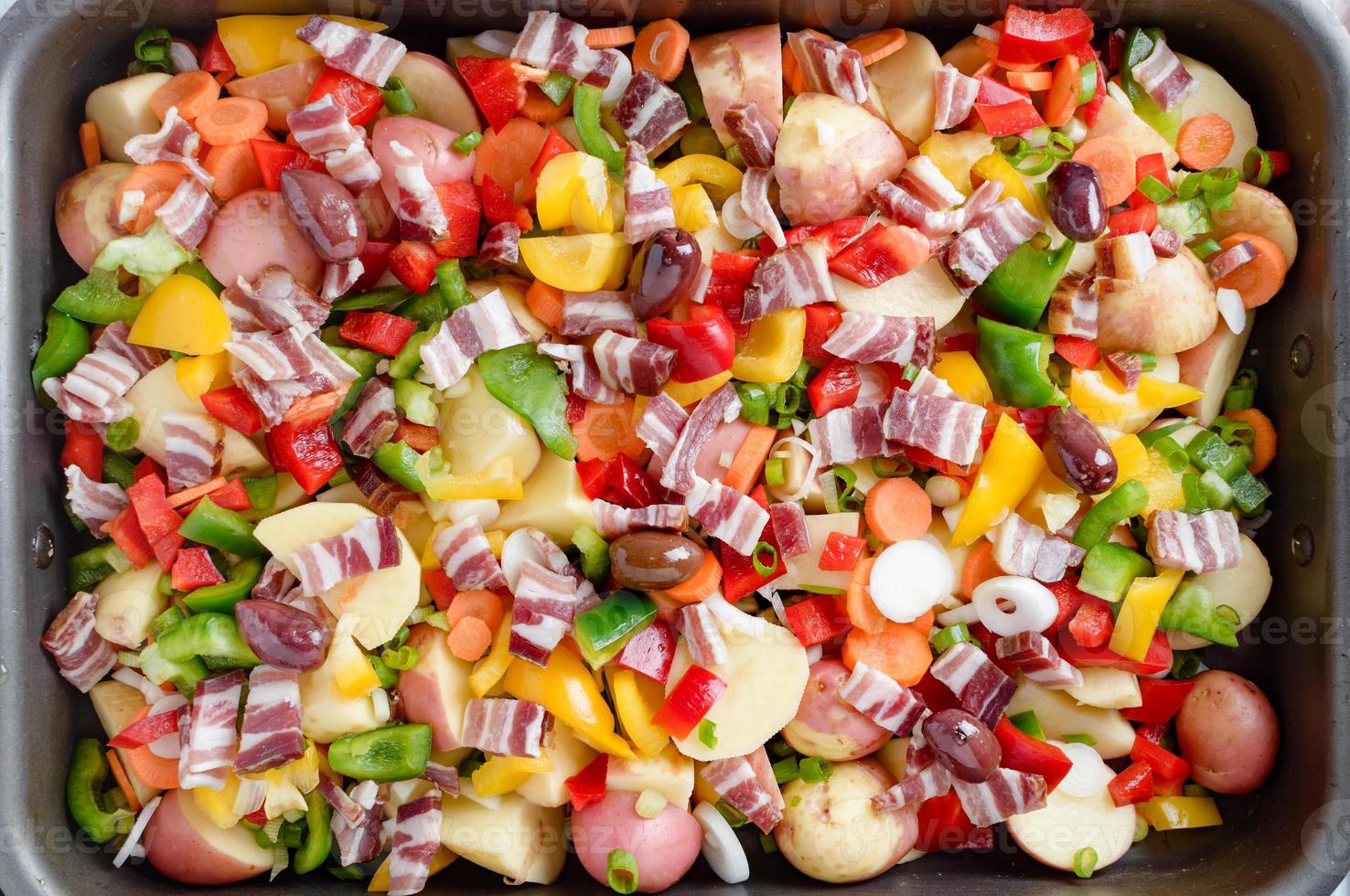 Potatoes baked with bacon, paprika, carrots, onions and several spices and olives. photo