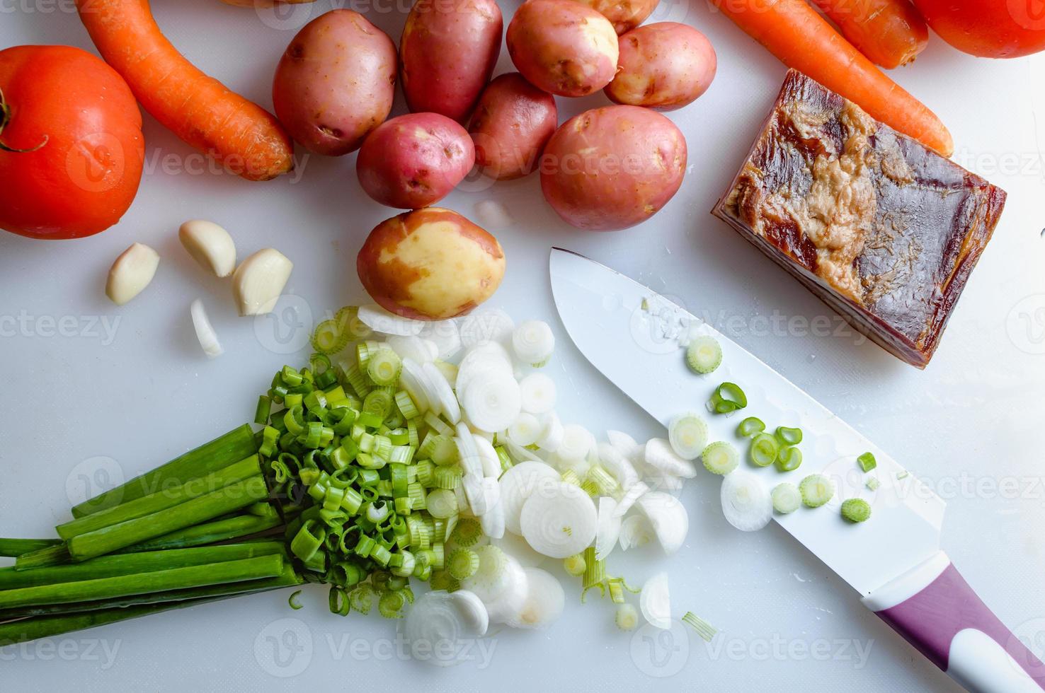 Spring vegetables and bacon on the kitchen table.Healthy foods are on the table. Homemade food preparation. photo