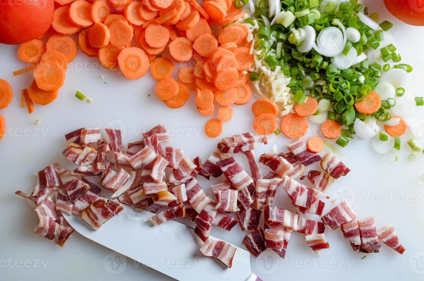 Spring vegetables and bacon on the kitchen table.Healthy foods are on the table. Homemade food preparation. photo