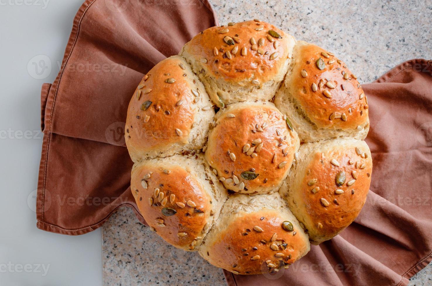 Loaf of bread on a kitchen worktable. Semisweet homemade bread with raisins, honey and various seeds. photo