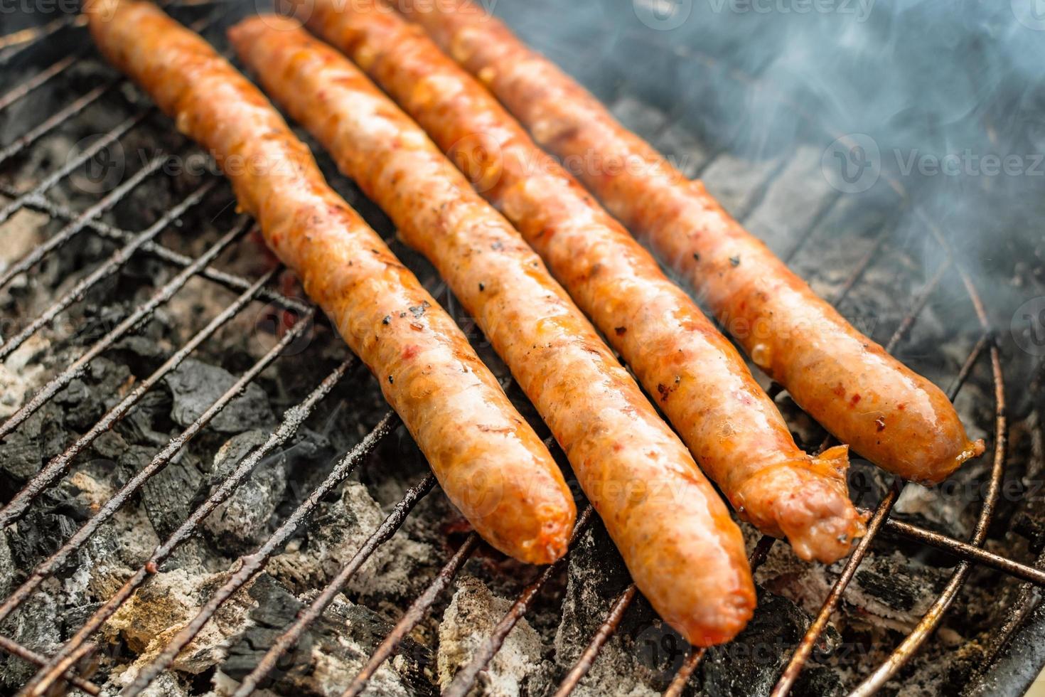 Grilled sausage on barbecue, grill. Shallow depth of field. photo