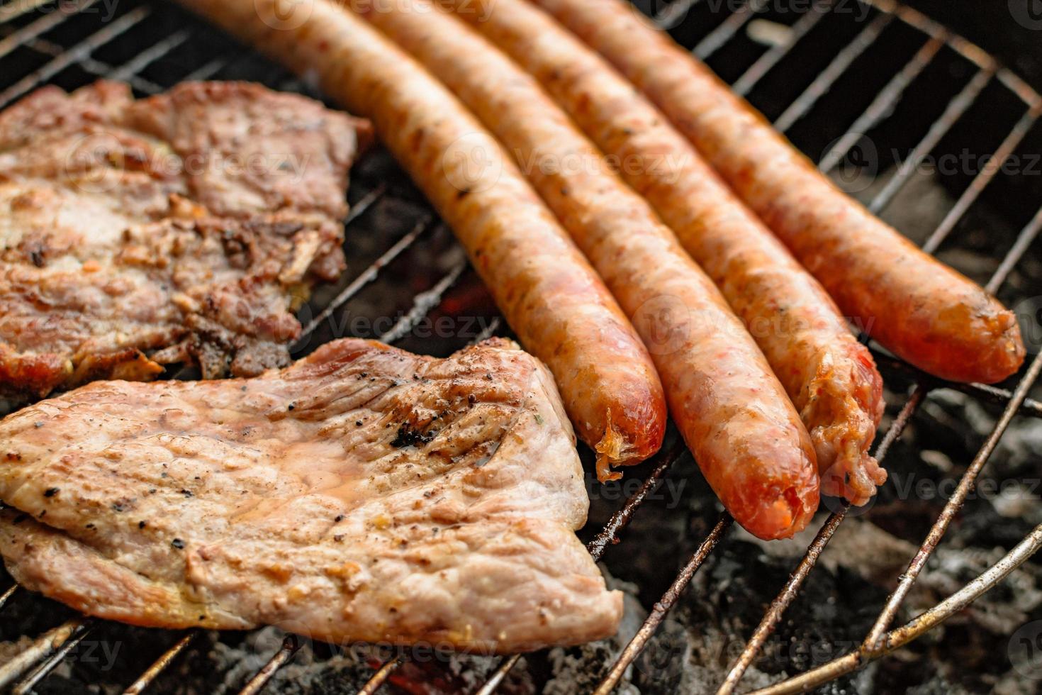 Grilled meat, pork, beef and sausage on barbecue, grill. Shallow depth of field. photo