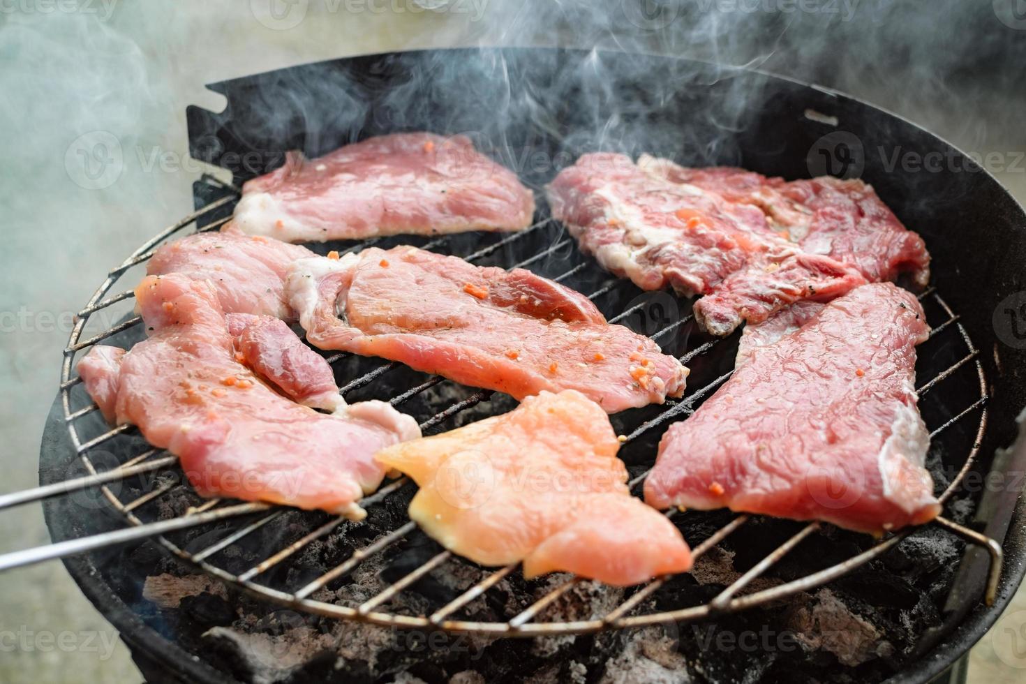 Grilled meat, pork, beef and chicken meat on barbecue, grill. Shallow depth of field. photo