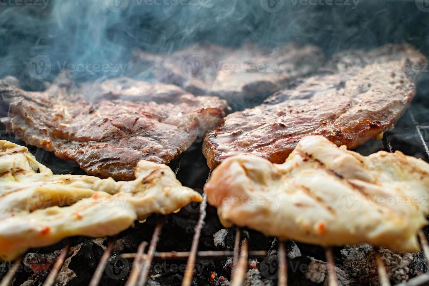 Grilled meat, pork, beef and chicken meat on barbecue, grill. Shallow depth of field. photo